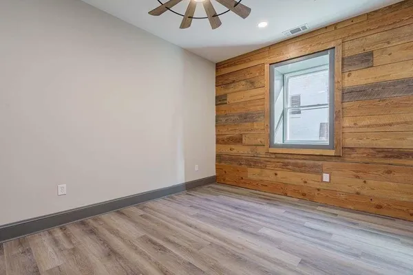 an empty room with closet and fan