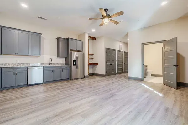 a view of a kitchen with a sink dishwasher refrigerator and a cabinets