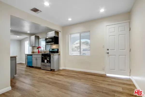 a kitchen with stainless steel appliances kitchen island granite countertop a stove and a refrigerator