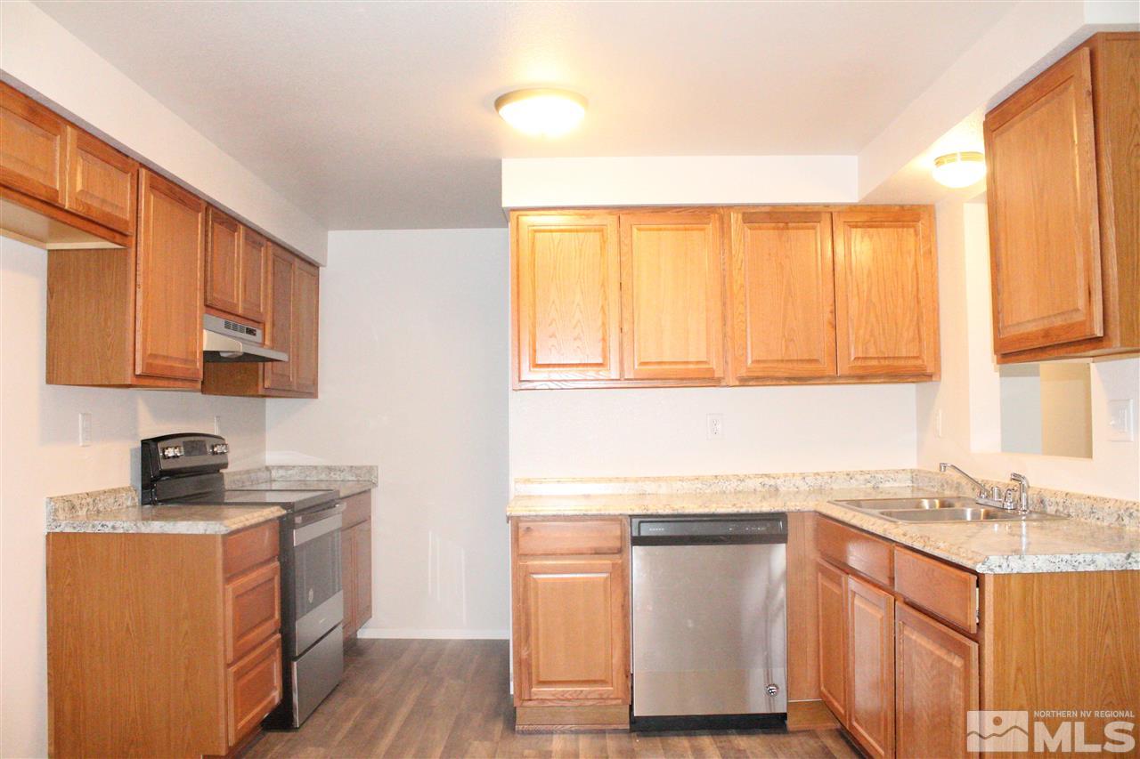 6630 Lotus Street Reno, NV 89506 - Photo 8 of 21 a kitchen with stainless steel appliances granite countertop a sink stove and cabinets