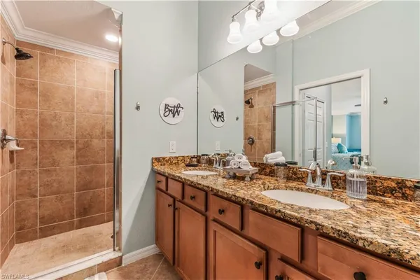 a bathroom with a granite countertop sink a mirror and a shower