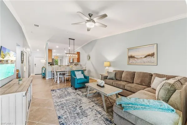 a living room with furniture kitchen view and a large window