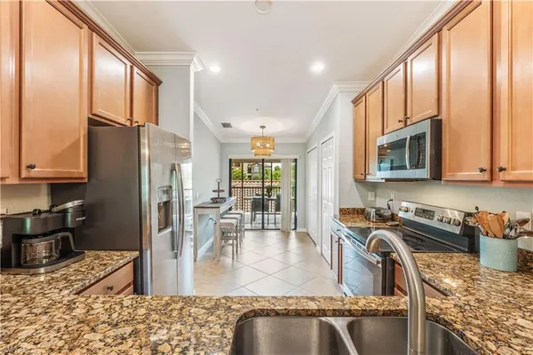 a kitchen with stainless steel appliances granite countertop a refrigerator a stove top oven a sink and dishwasher