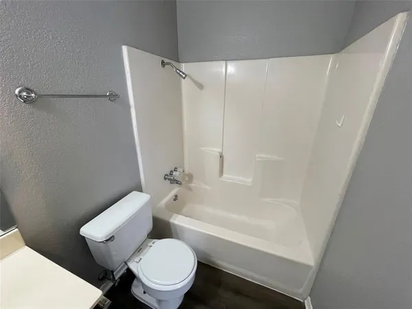 a white toilet sitting next to a bath tub