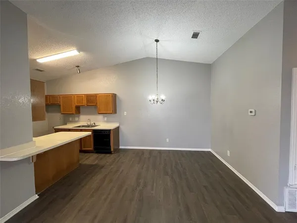 a large kitchen with a wooden floor and a sink