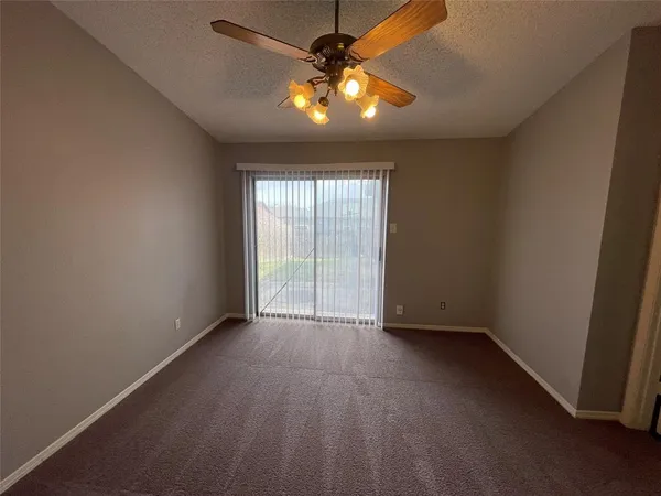an empty room with window and chandelier fan