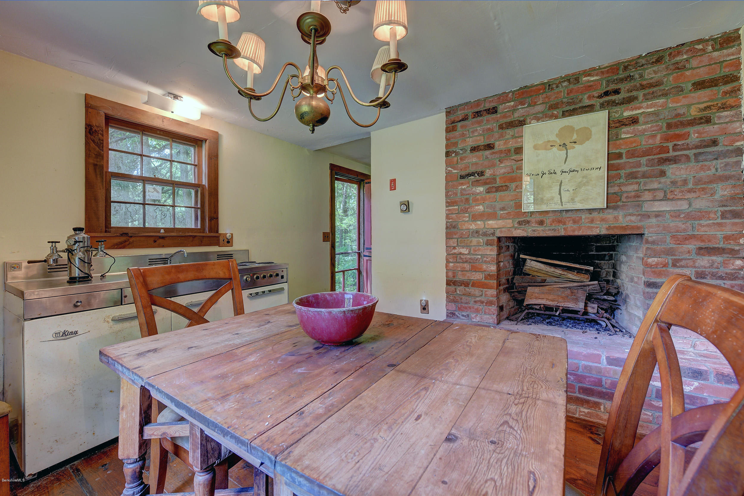 82 Hammertown Road Sandisfield, MA 01255 - Photo 37 of 49 a dining room with wooden floor a chandelier a wooden table and chairs