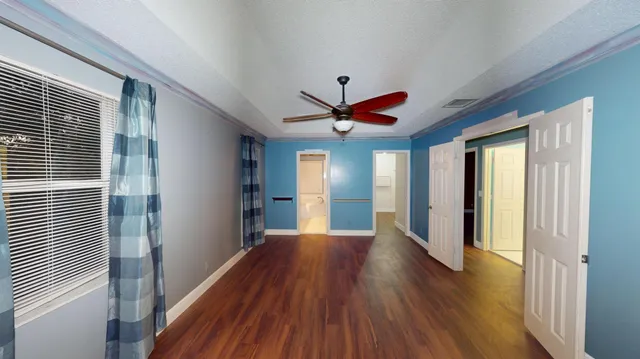 a view of a livingroom with wooden floor and a ceiling fan