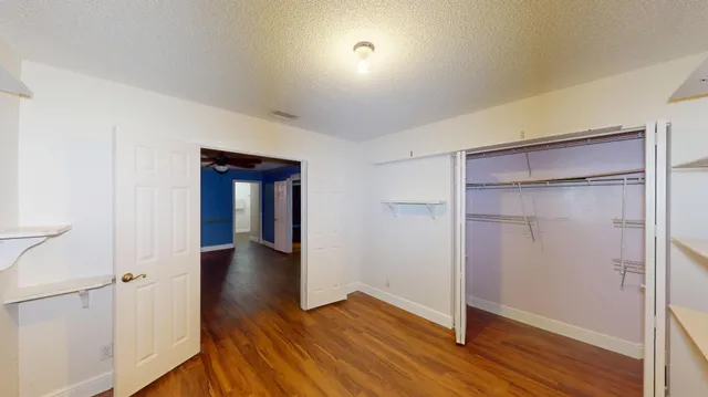 a view of an empty room with wooden floor