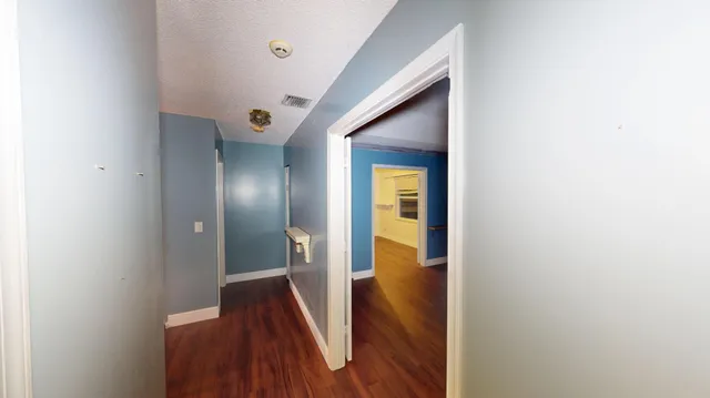 a view of a hallway with wooden floor