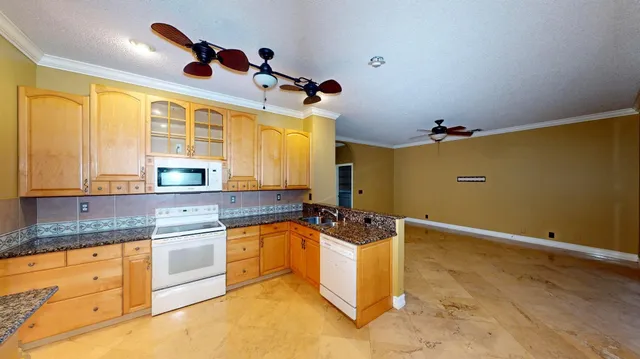 a kitchen with granite countertop a sink a counter top space appliances and cabinets