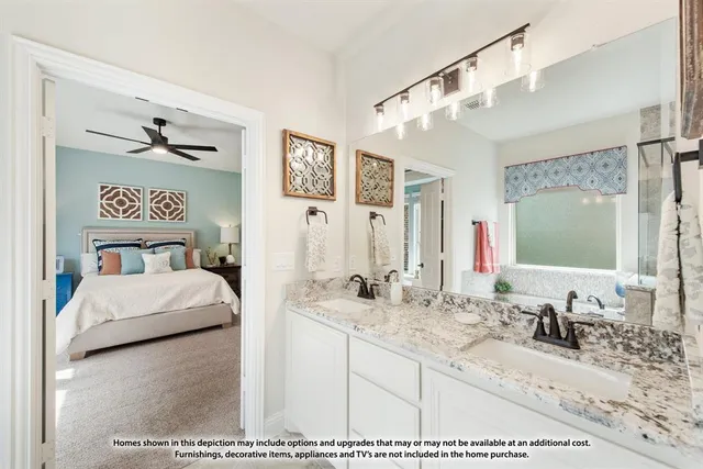 a en suite bathroom with a granite countertop sink and a mirror