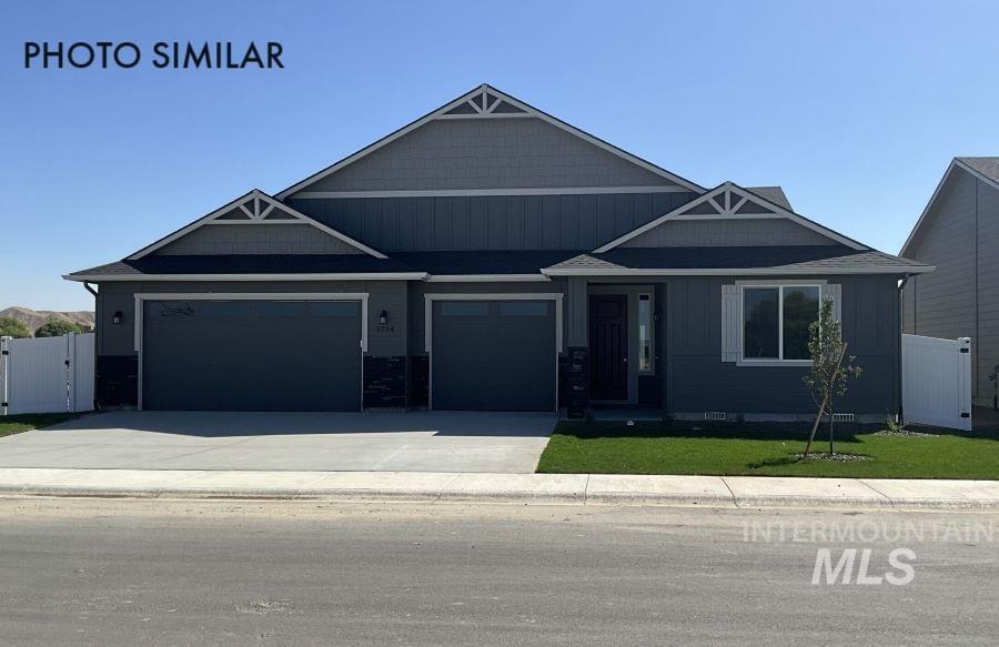 1645 Haystack Emmett, ID 83617 - Photo 1 of 33 Contemporary exterior featuring dark gray siding with contrasting lighter gray gables, a two-car garage, white window shutters, and a covered entryway