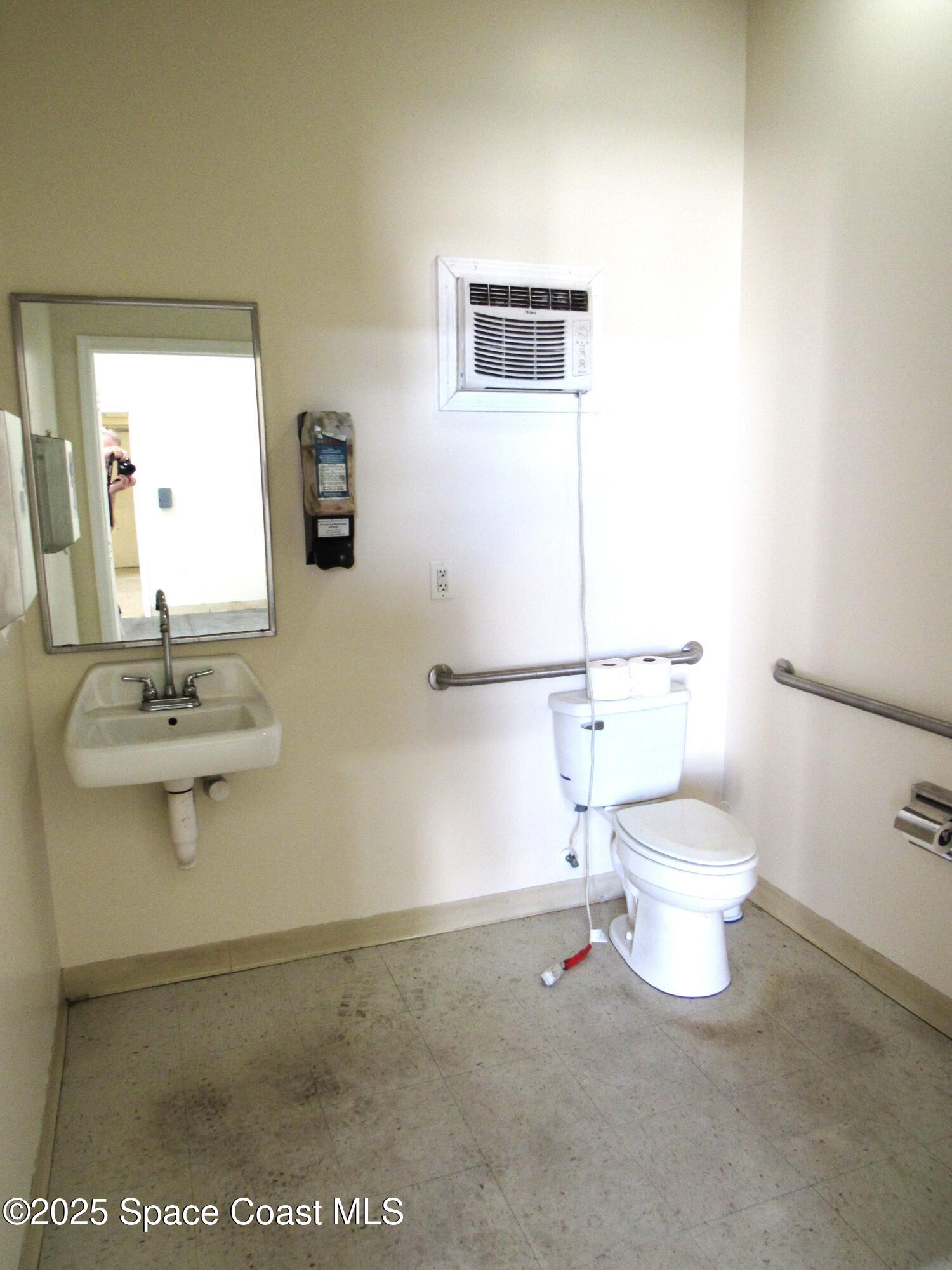 658 Atlantis Road, Unit 105 Melbourne, FL 32904 - Photo 8 of 12 a bathroom with a sink a toilet and a mirror