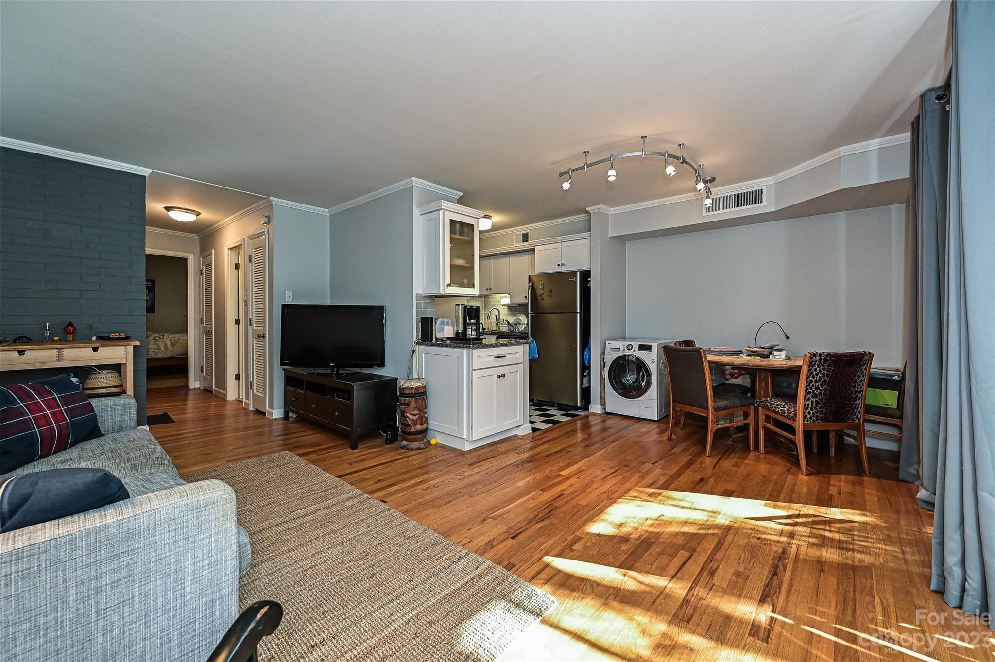 400 Queens Road, Unit B5 Charlotte, NC 28207 - Photo 7 of 20 a living room with furniture a dining table and a flat screen tv