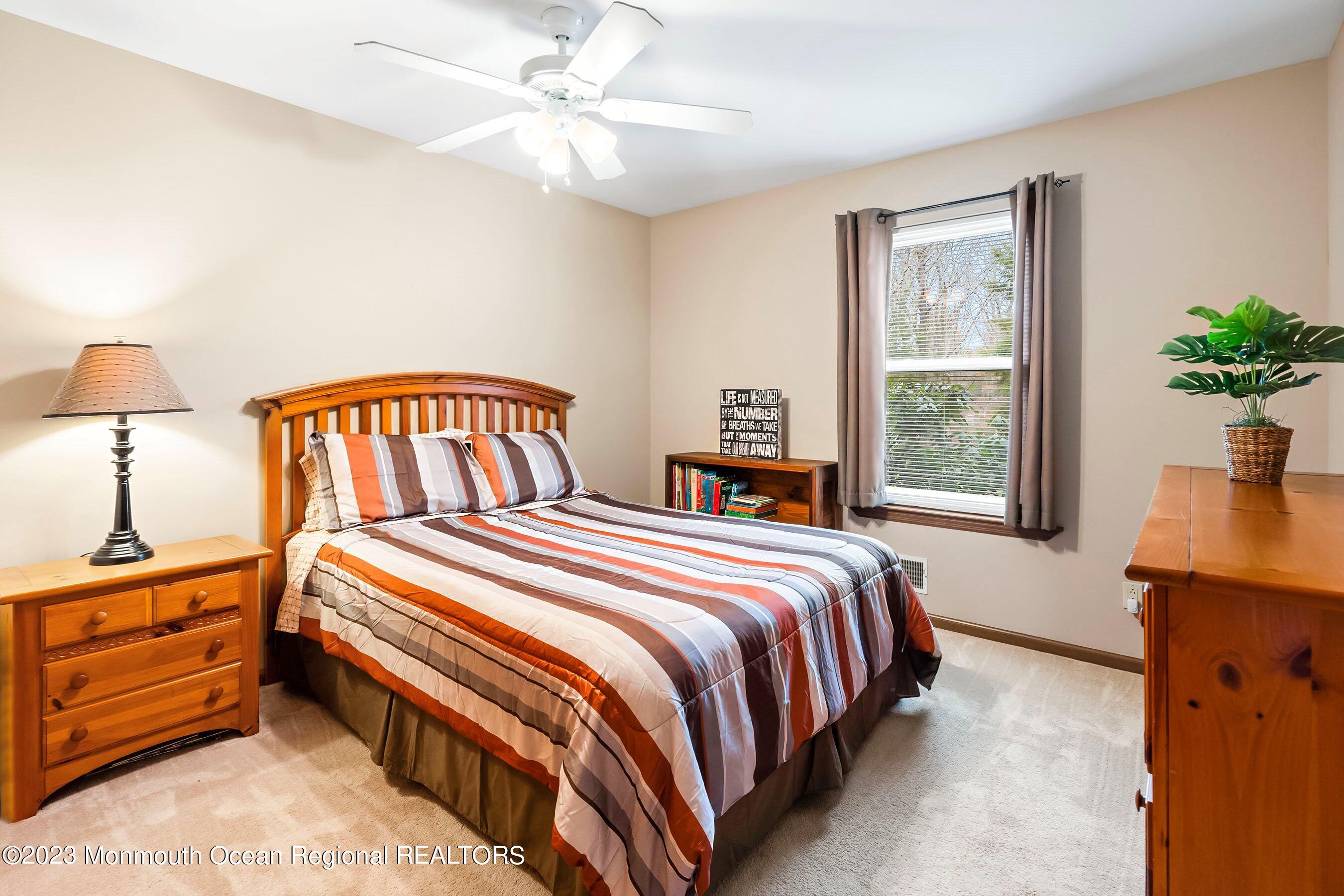 310 Easy Street Howell, NJ 07731 - Photo 21 of 45 a bedroom with a bed a chandelier and a window