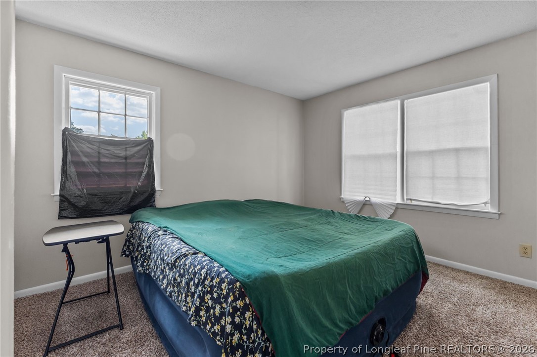 908 Ruton Court Fayetteville, NC 28303 - Photo 24 of 29 a bedroom with a bed window and mirror