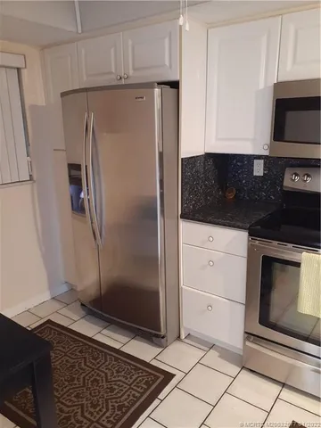 a kitchen with granite countertop a refrigerator and a stove