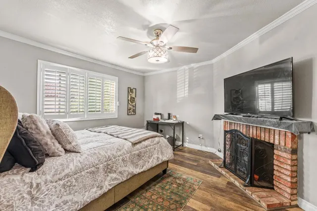 a bedroom with a large bed a flat tv screen and a fireplace