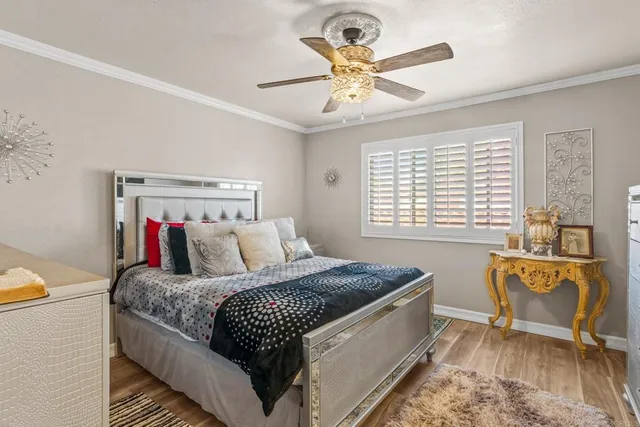 a bedroom with a large bed a chandelier and a window