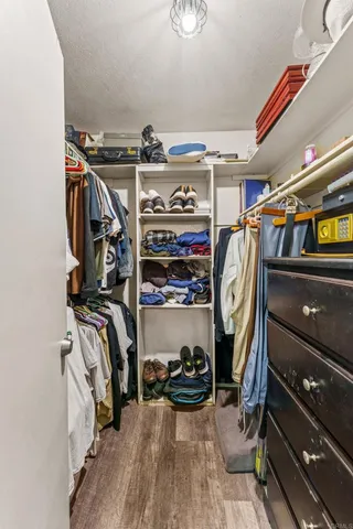 a view of walk in closet with clothes and shoes