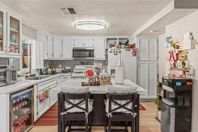 a kitchen with stainless steel appliances cabinets a dining table and chairs