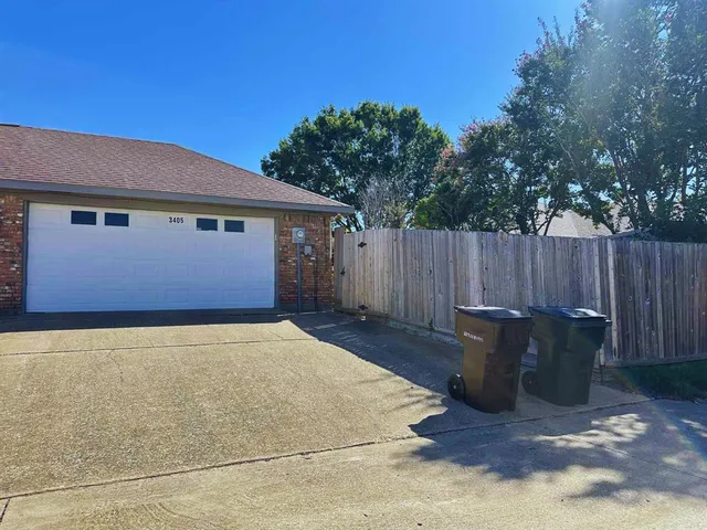 a backyard of house with wooden fence and a bench