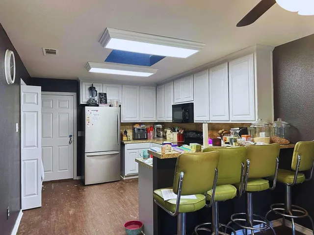 a kitchen with stainless steel appliances a refrigerator and a dining table