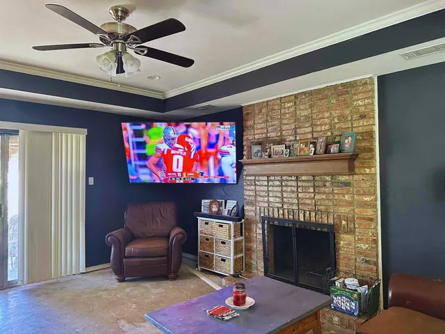 a living room with furniture a fireplace and a flat screen tv