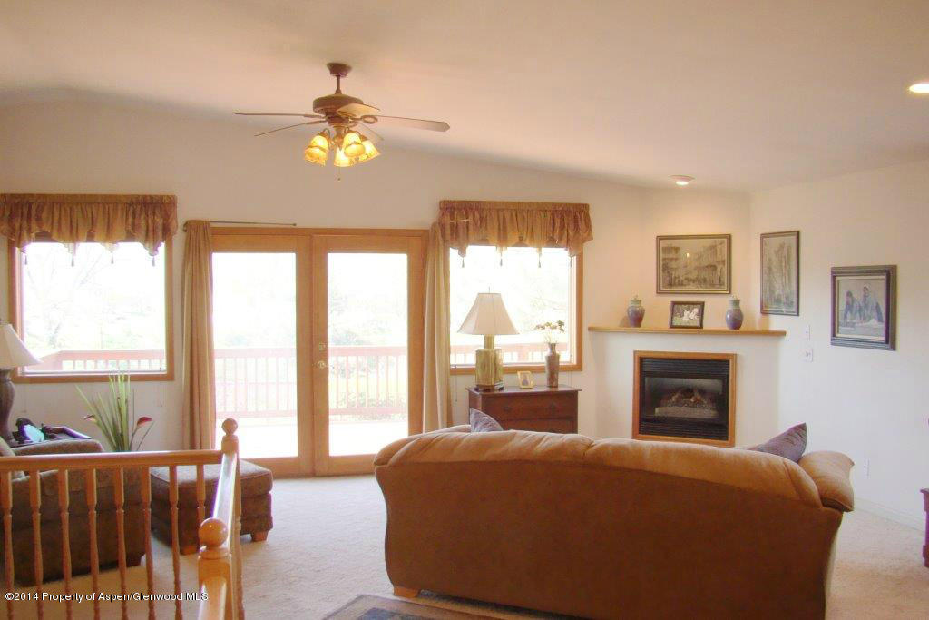 1001 Arnold Court Rifle, CO 81650 - Photo 11 of 39 a bedroom with a balcony a bed and a fireplace