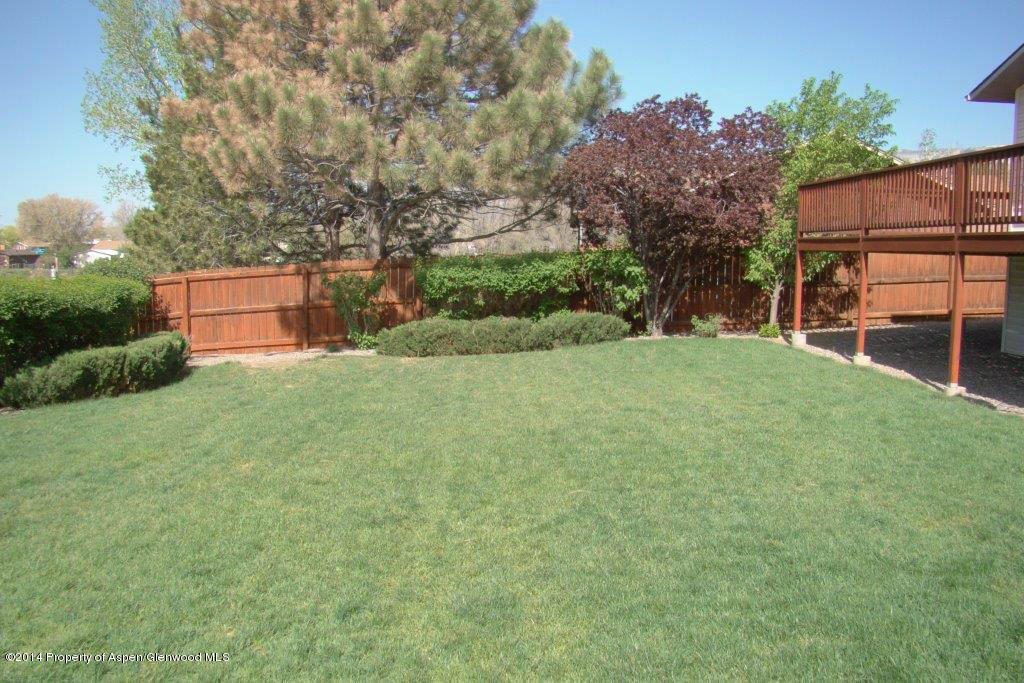 1001 Arnold Court Rifle, CO 81650 - Photo 32 of 39 a backyard of a house with plants and large trees