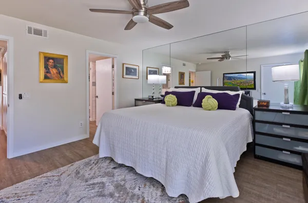 a bed room with a bed and a painting on the wall