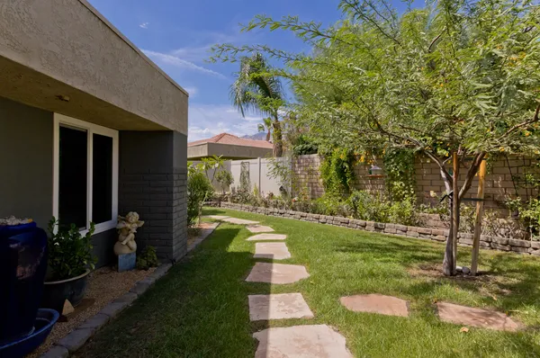a living room with patio furniture and a potted plant