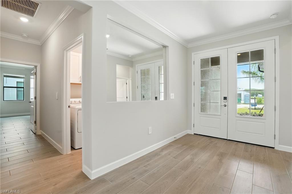 20489 Verawood Loop Estero, FL 33928 - Photo 15 of 50 Doorway with ornamental molding, french doors, wood finished floors, and washer / clothes dryer