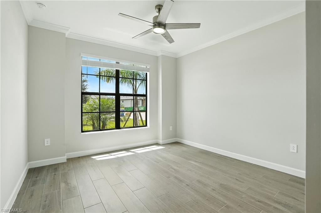 20489 Verawood Loop Estero, FL 33928 - Photo 19 of 50 Unfurnished room featuring crown molding, light wood-style flooring, and ceiling fan