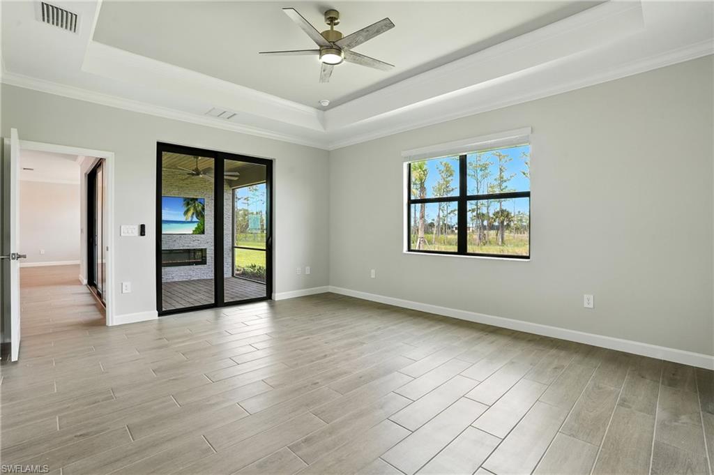 20489 Verawood Loop Estero, FL 33928 - Photo 27 of 50 Spare room with a tray ceiling, ornamental molding, healthy amount of natural light, and light wood-type flooring