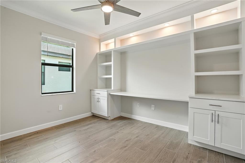 20489 Verawood Loop Estero, FL 33928 - Photo 33 of 50 Unfurnished office featuring crown molding, wood tiled floors, built in desk, and a ceiling fan