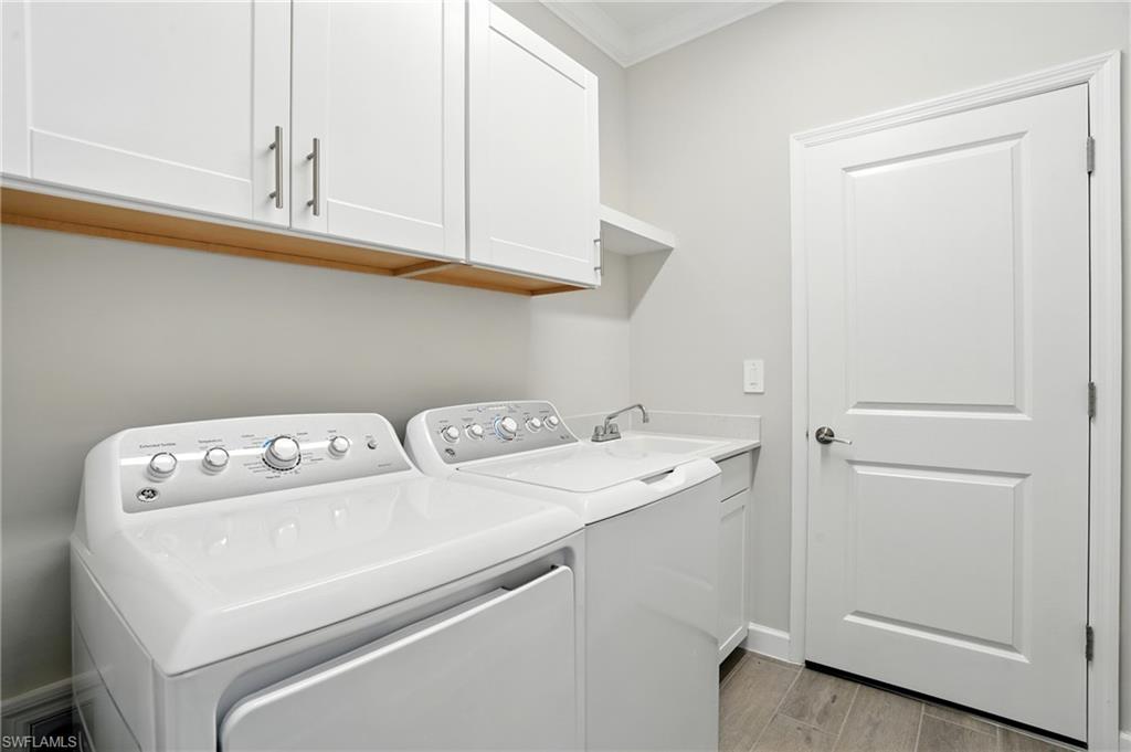 20489 Verawood Loop Estero, FL 33928 - Photo 36 of 50 Washroom featuring crown molding, wood finish floors, washer and dryer, and cabinet space