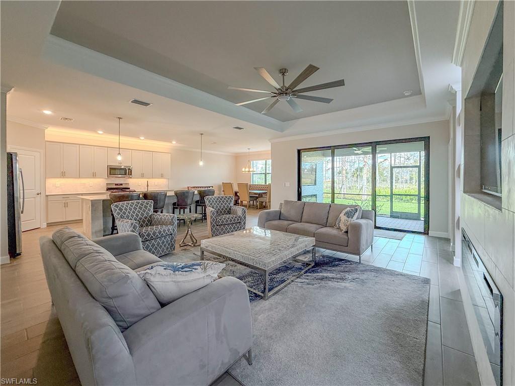 20489 Verawood Loop Estero, FL 33928 - Photo 8 of 50 Living room featuring crown molding, ceiling fan, a tray ceiling, a fireplace, and recessed lighting