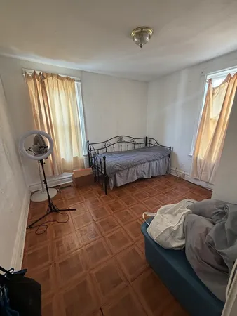 a bedroom with a bed and wooden floor