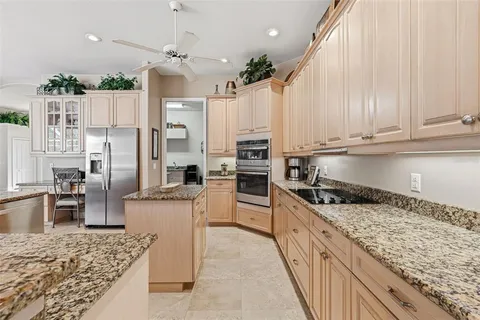 a kitchen with granite countertop a sink stainless steel appliances and white cabinets