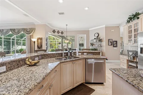 a living room with furniture kitchen view and a chandelier