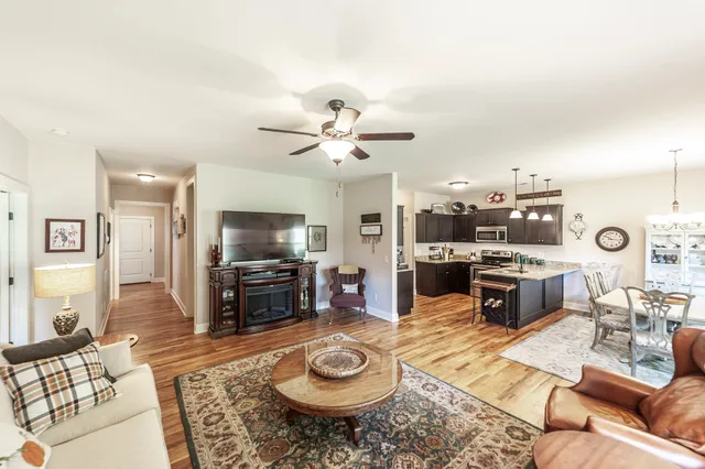 a living room with furniture a flat screen tv and kitchen view