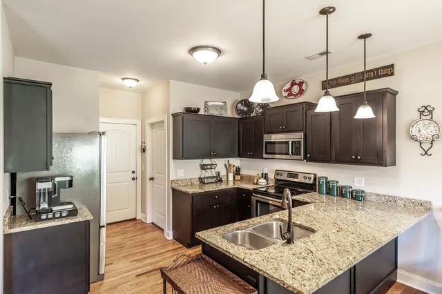 a kitchen with kitchen island granite countertop a sink and a stove