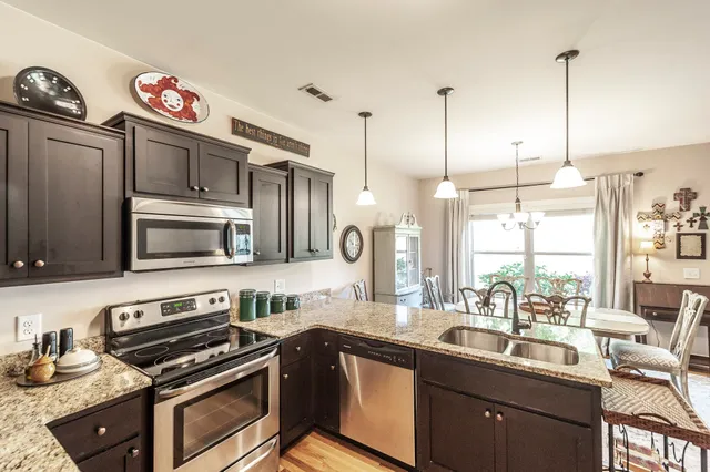 a kitchen with stainless steel appliances a stove a sink and a microwave