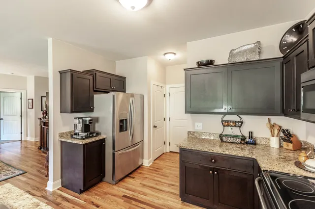 a kitchen with granite countertop a refrigerator and a sink
