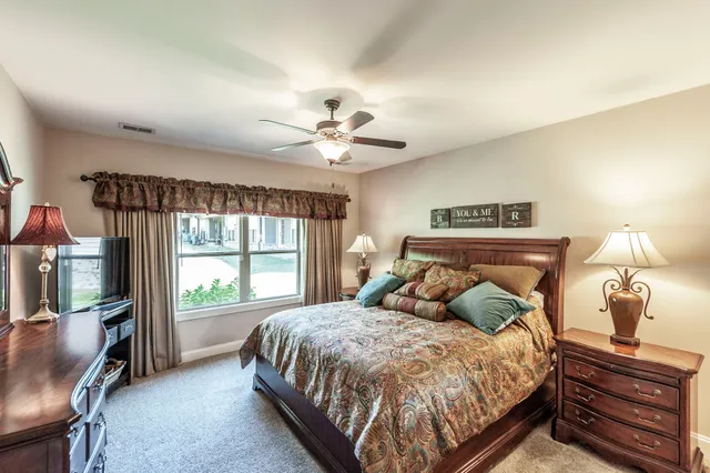 a bedroom with a large bed and a chandelier