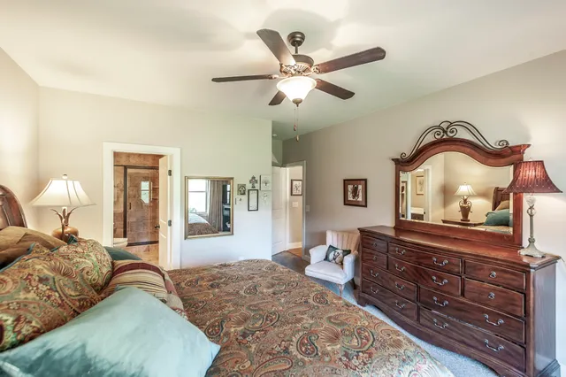 a bedroom with a bed and dresser with mirror