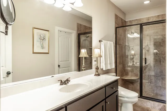 a bathroom with a sink a toilet and shower