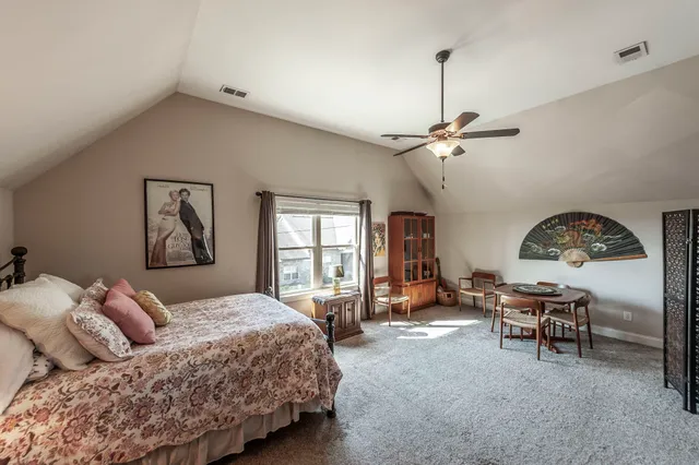 a bedroom with a bed a table and chair